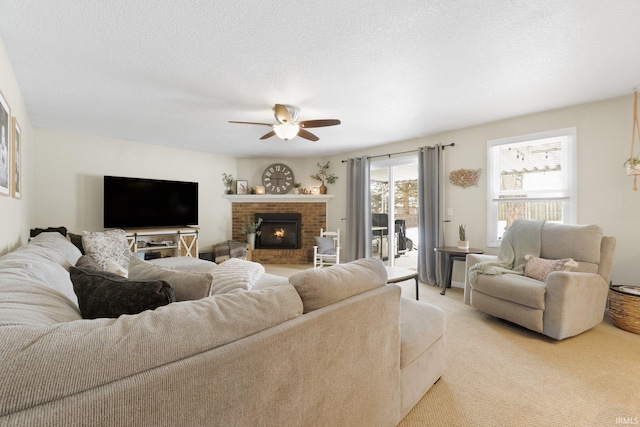 living room with light carpet, a brick fireplace, ceiling fan, and a textured ceiling