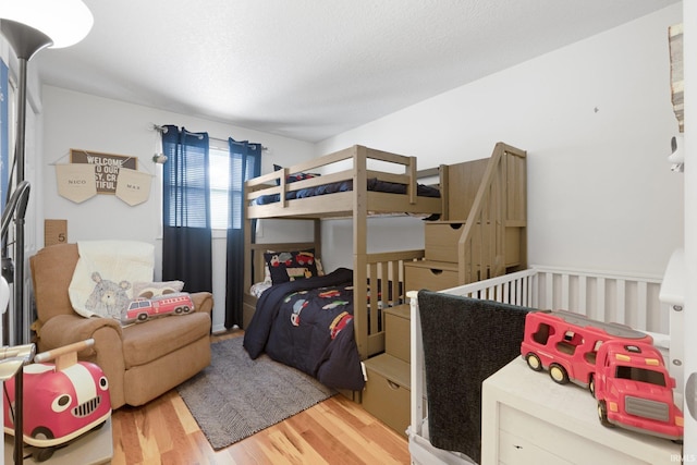 bedroom with a textured ceiling and wood finished floors