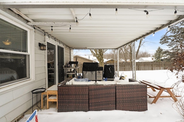 snow covered patio featuring fence and an outdoor hangout area