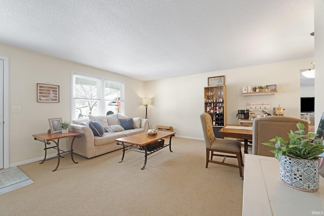 living room with light carpet, a textured ceiling, and baseboards