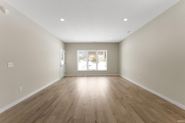 unfurnished room featuring light wood-type flooring, baseboards, and recessed lighting