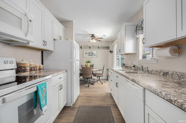 kitchen with white appliances, ceiling fan, white cabinetry, and a sink