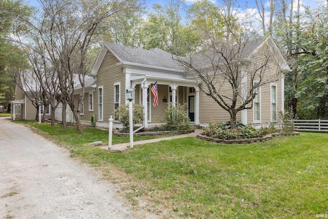 view of front of house featuring driveway, a front yard, and fence