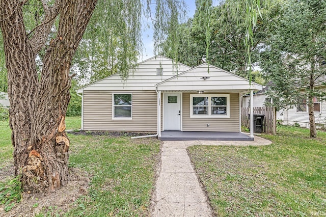 bungalow-style home featuring covered porch and a front lawn