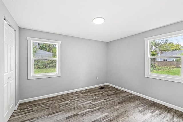 spare room with visible vents, dark wood finished floors, and baseboards