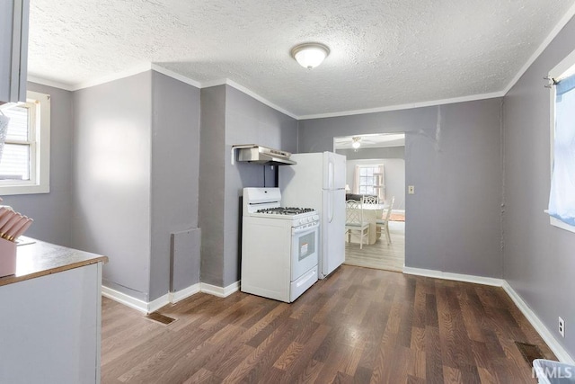 kitchen with white appliances, dark wood-type flooring, visible vents, and under cabinet range hood