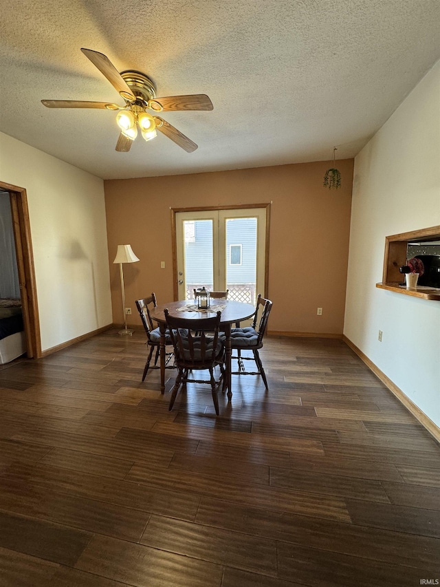 dining area featuring a textured ceiling, dark wood-type flooring, a ceiling fan, and baseboards