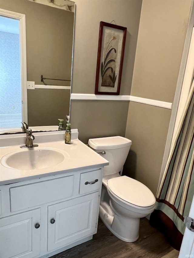 full bathroom with toilet, wood finished floors, and vanity