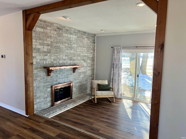 unfurnished room featuring dark wood finished floors, a fireplace, and a textured ceiling