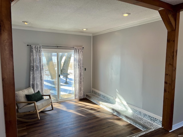 living area with dark wood-type flooring, crown molding, a textured ceiling, and baseboards