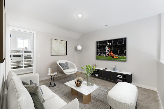 carpeted living room featuring vaulted ceiling and baseboards