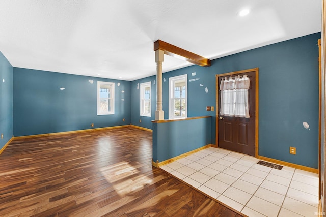 foyer entrance featuring visible vents, baseboards, and wood finished floors