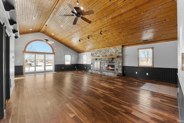 unfurnished living room with wood ceiling, wainscoting, a fireplace, and wood finished floors