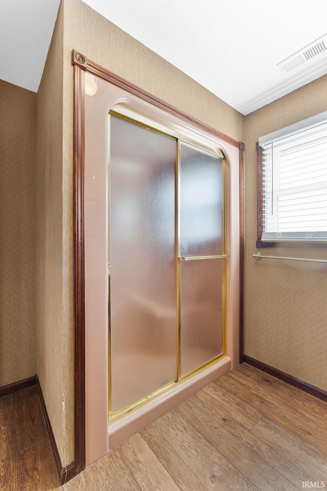 bathroom with wallpapered walls, baseboards, visible vents, and wood finished floors