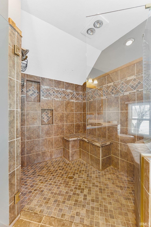 full bath with lofted ceiling and a tile shower