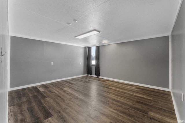 unfurnished room with dark wood-type flooring, a textured ceiling, and baseboards