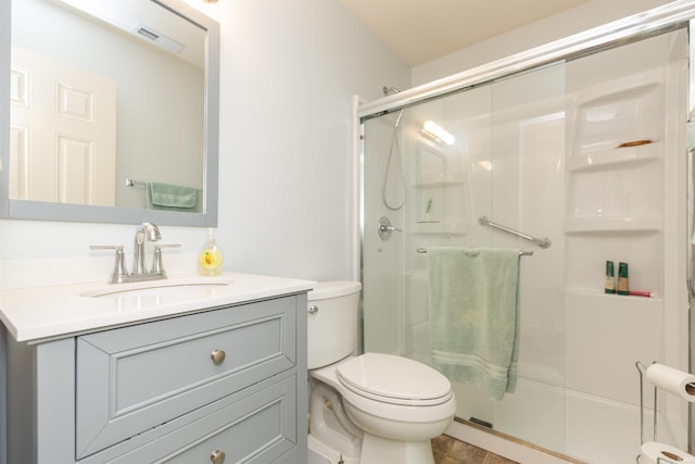 full bathroom featuring a stall shower, visible vents, vanity, and toilet