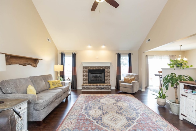 living room featuring a brick fireplace, dark wood-style flooring, and visible vents