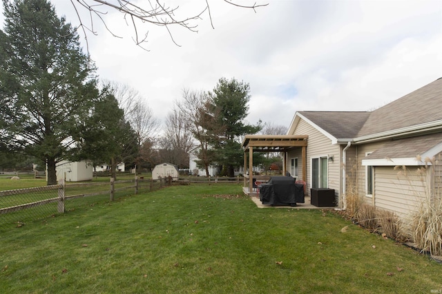 view of yard featuring a storage unit, a patio area, a fenced backyard, and an outdoor structure