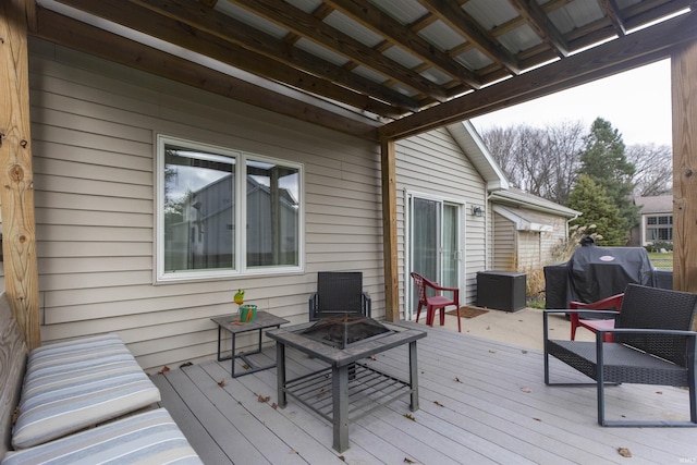 wooden deck with an outdoor fire pit and a grill