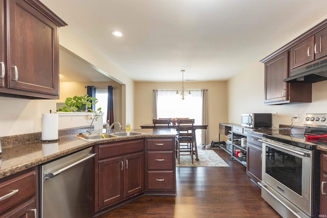 kitchen with decorative light fixtures, appliances with stainless steel finishes, dark wood-type flooring, a sink, and under cabinet range hood