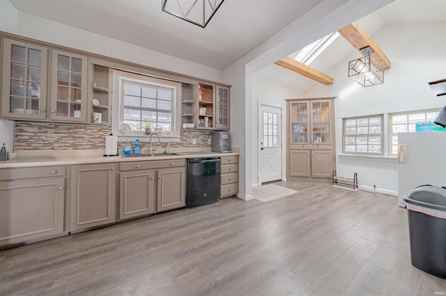 kitchen with black dishwasher, open shelves, light countertops, glass insert cabinets, and a sink