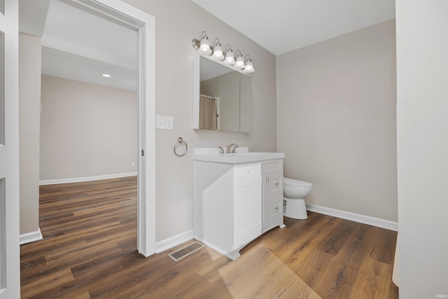 full bath with toilet, vanity, visible vents, and baseboards