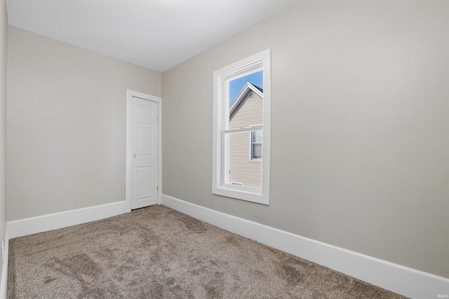 empty room with baseboards and carpet flooring