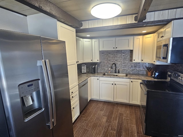 kitchen with dark wood-style floors, backsplash, appliances with stainless steel finishes, white cabinets, and a sink