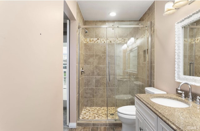 full bathroom with a stall shower, vanity, and toilet