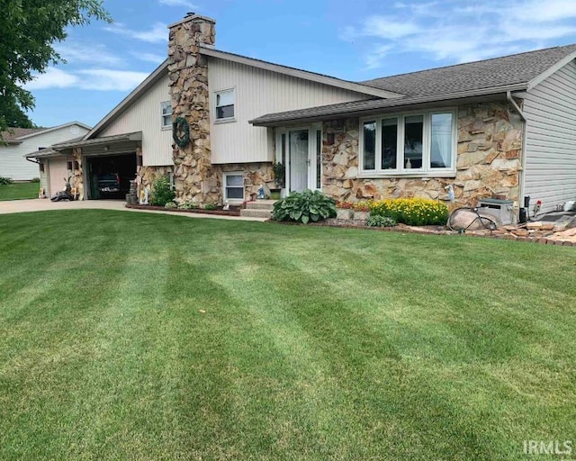 tri-level home with a front yard, stone siding, and a chimney