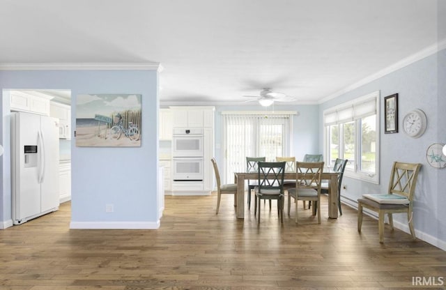 dining space featuring ceiling fan, baseboards, dark wood finished floors, and ornamental molding