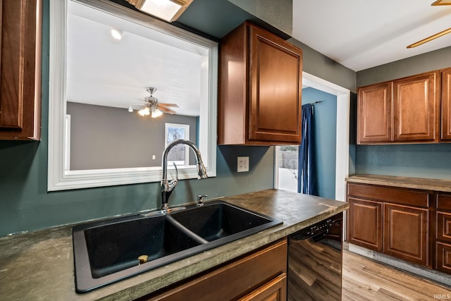 kitchen featuring a ceiling fan, black dishwasher, brown cabinets, and a sink