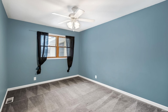 empty room with carpet floors, visible vents, ceiling fan, and baseboards