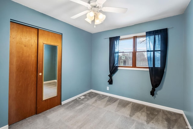 unfurnished bedroom with ceiling fan, carpet, visible vents, and baseboards