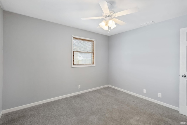 empty room with a ceiling fan, carpet flooring, visible vents, and baseboards