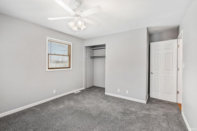 unfurnished bedroom featuring a closet, dark carpet, baseboards, and ceiling fan