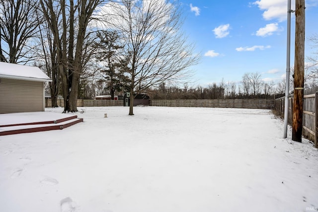 yard layered in snow featuring a fenced backyard