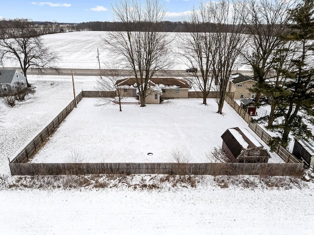 snowy yard featuring fence