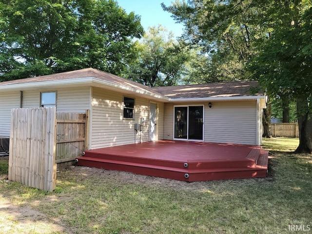 exterior space with a lawn, a deck, and fence