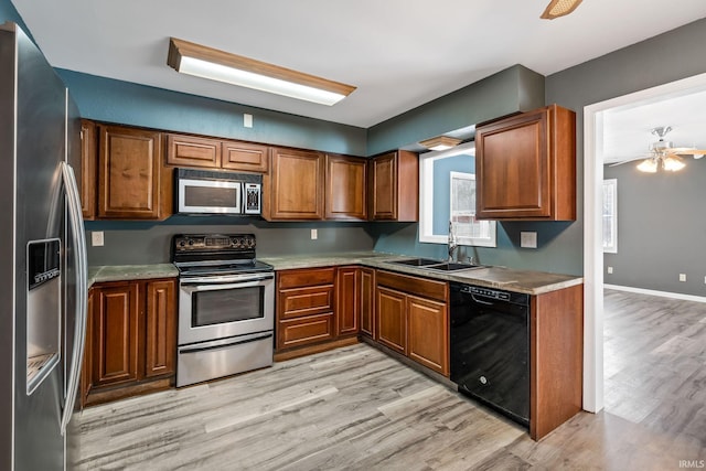 kitchen with brown cabinets, appliances with stainless steel finishes, light countertops, and a sink