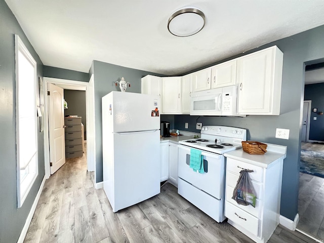 kitchen with white cabinets, white appliances, a healthy amount of sunlight, and light countertops