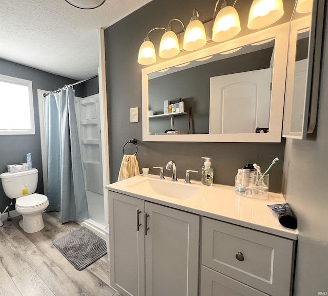 bathroom featuring a textured ceiling, a shower with shower curtain, wood finished floors, and vanity