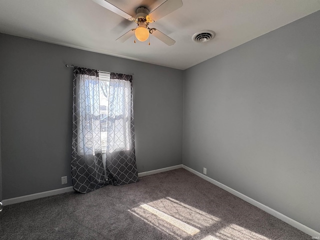 carpeted empty room with baseboards, visible vents, and ceiling fan