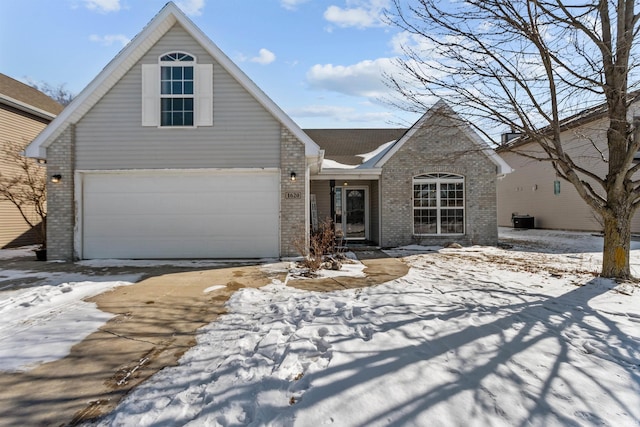 view of front of property with a garage, central air condition unit, and brick siding