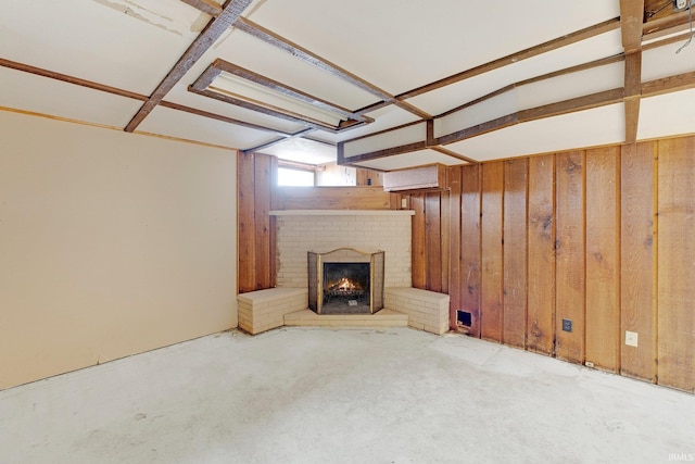 unfurnished living room with wood walls and a brick fireplace