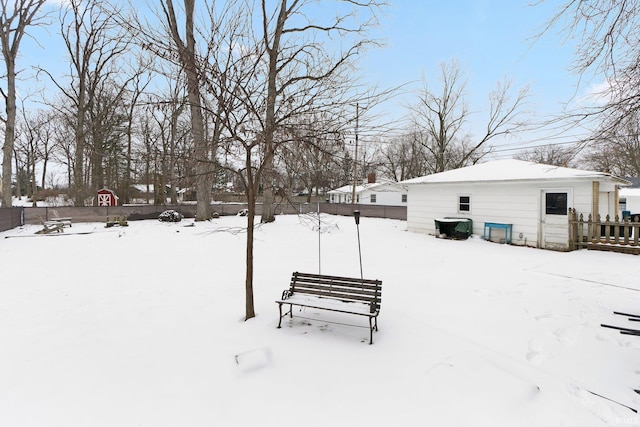 snowy yard featuring fence