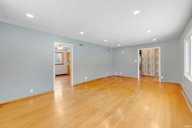 unfurnished room with recessed lighting, visible vents, light wood-style flooring, and baseboards