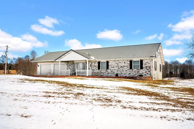 ranch-style home with metal roof and an attached garage