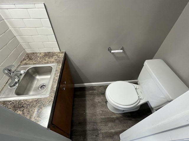 bathroom featuring baseboards, vanity, toilet, and wood finished floors